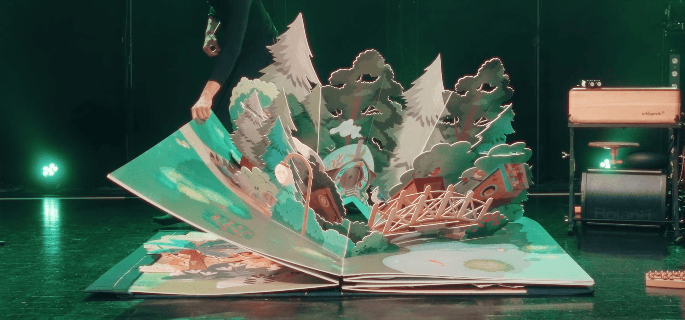 Livre pop-up ouvert sur la forêt du spectacle visuel et musical mille Voyages